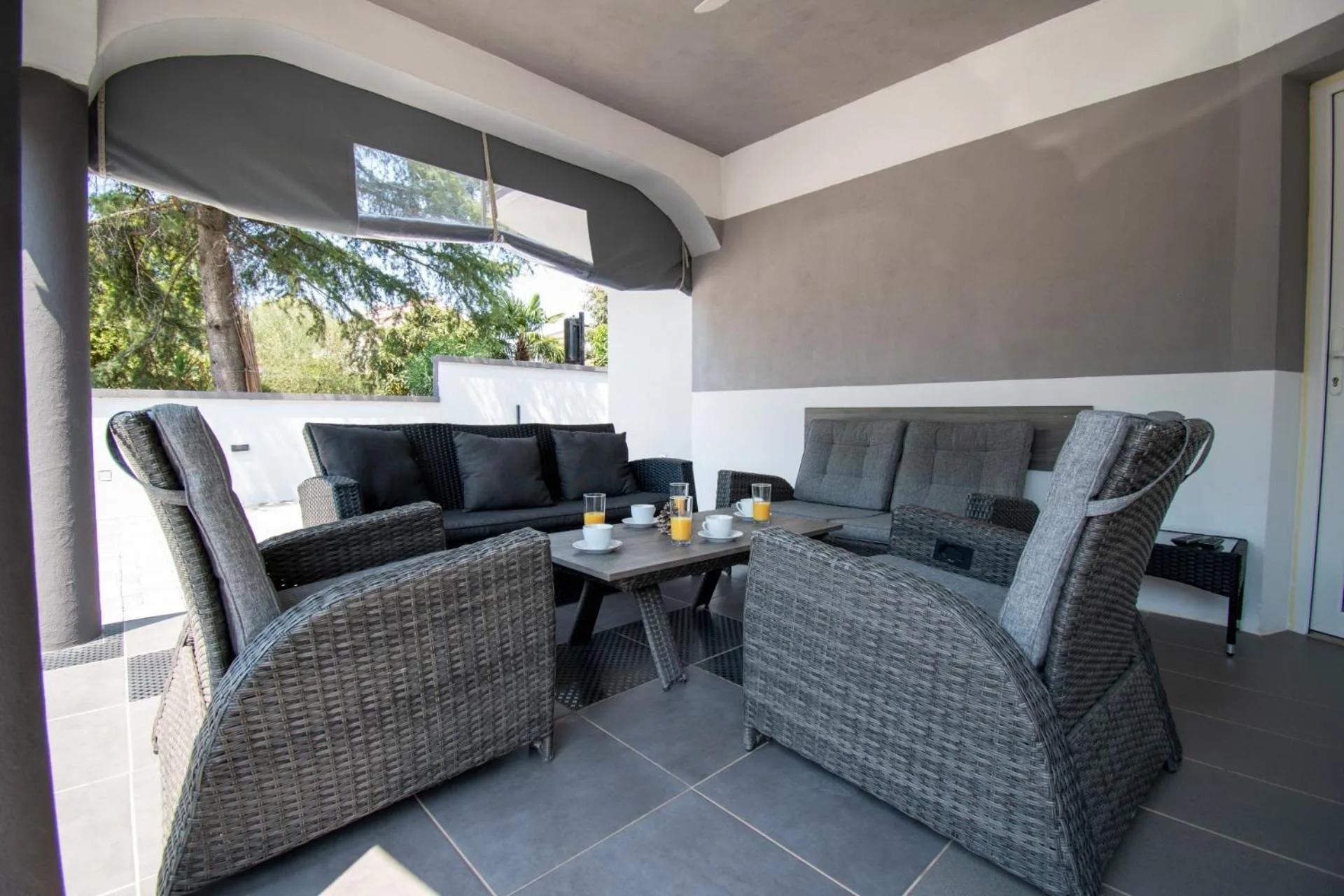 Überdachte Lounge-Terrasse mit Rattanmöbeln in der Vila Damjan