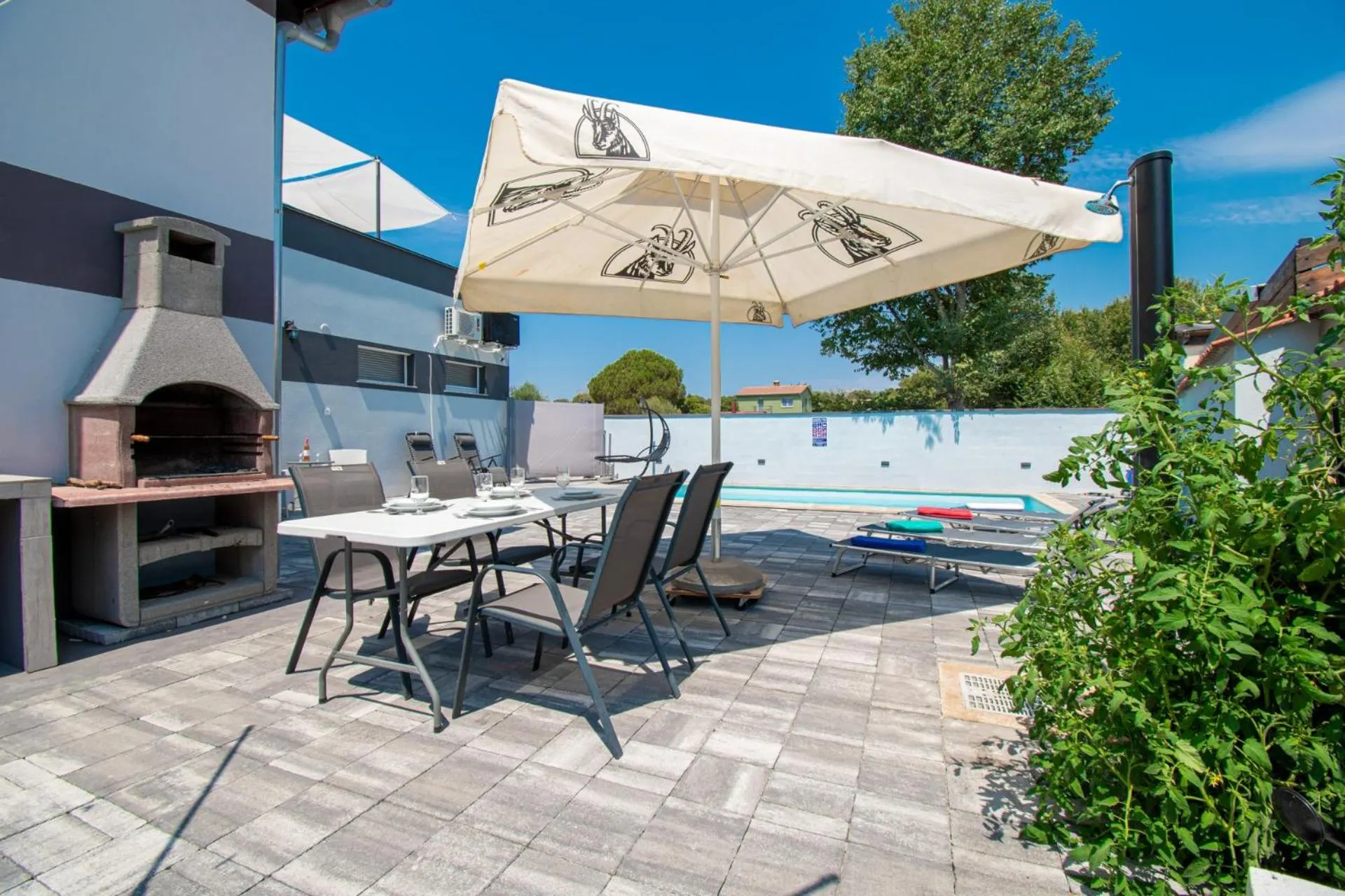 Grande tavolo accanto alla piscina e alla griglia in muratura