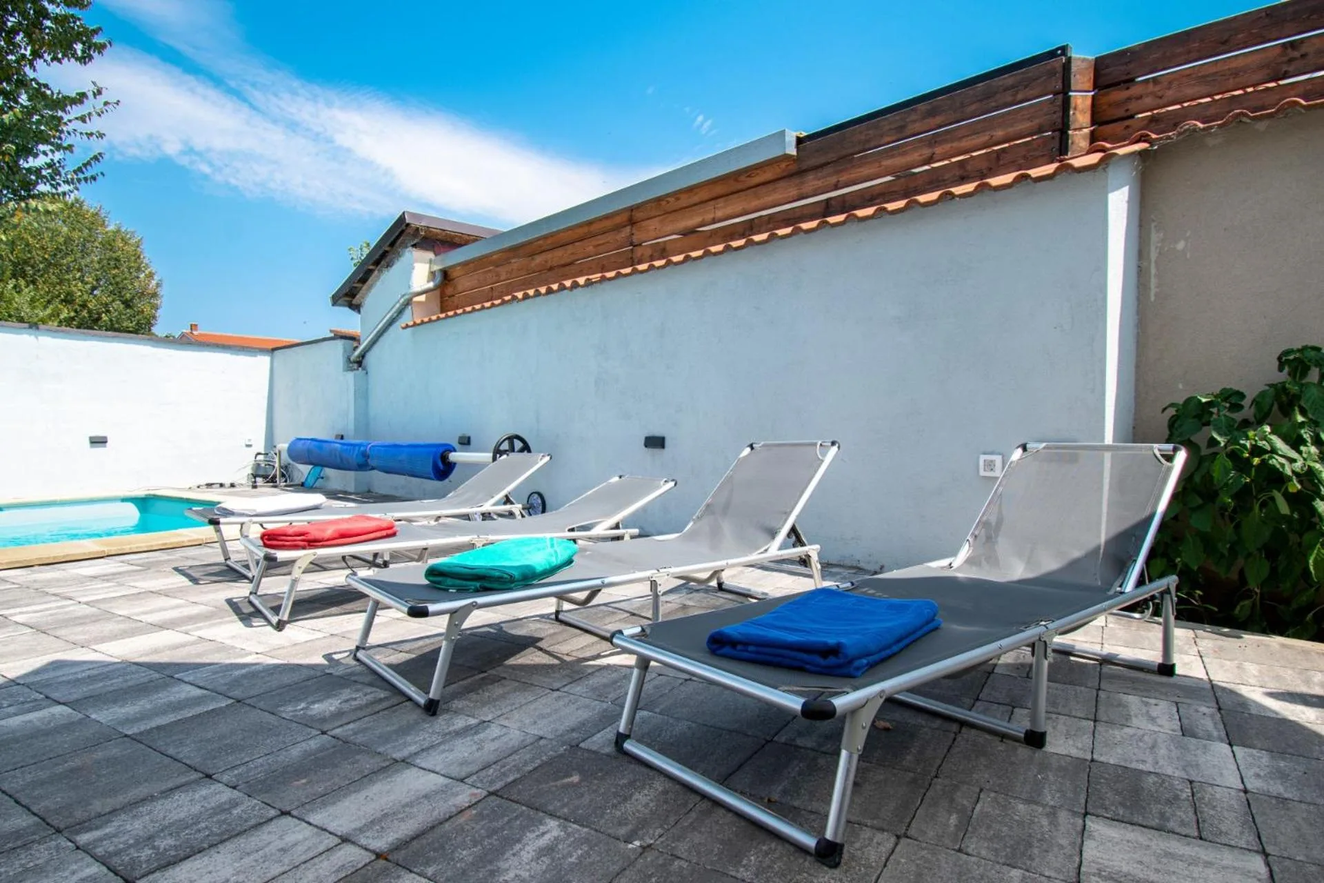 Sun loungers along the wall beside the pool